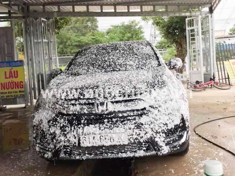 Phun dung dịch rửa xe lên bề mặt xe